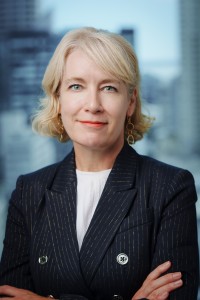 Headshot of Anna Adams, looking at the camera with arms crossed